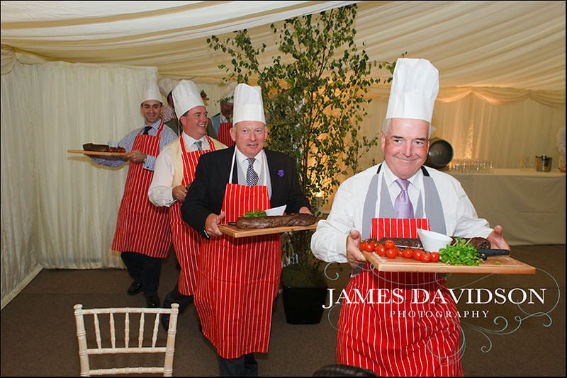 surrey wedding photographer 26 carrying food in to meal for carving